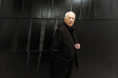 Pierre Soulages posant devant une de ses œuvres